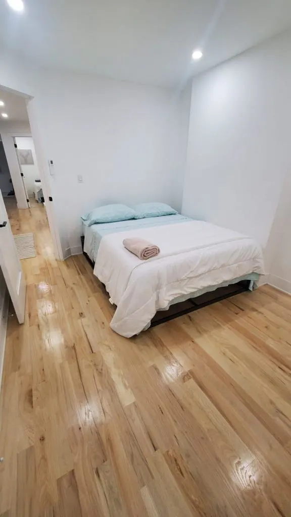 Minimalist bedroom with wooden flooring.