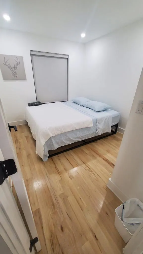 Minimalist bedroom with wooden flooring.