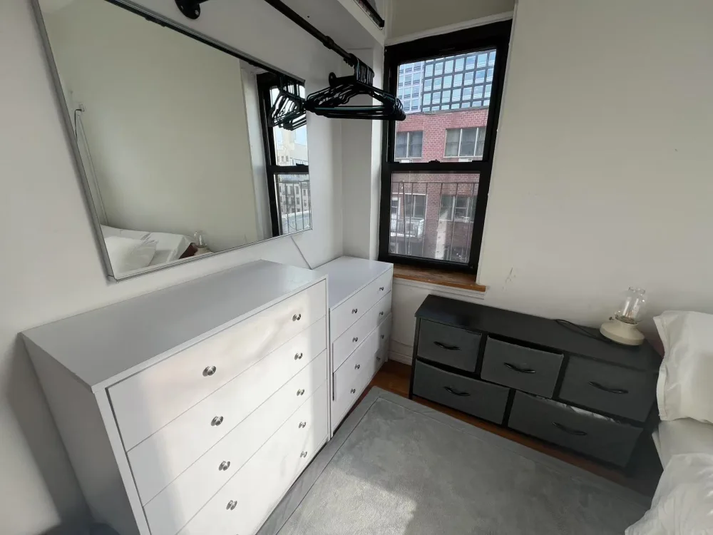 Small room with dressers and window.