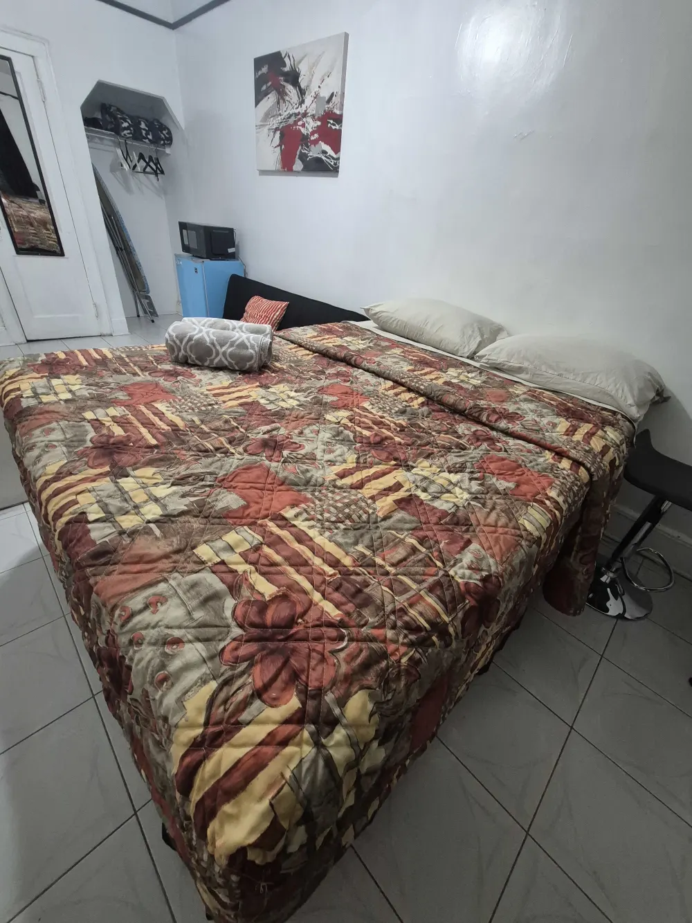 Room with a patterned bedspread.