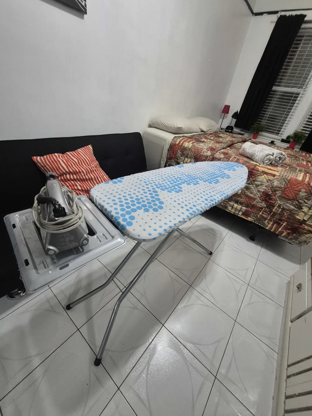 Cozy bedroom with ironing board.