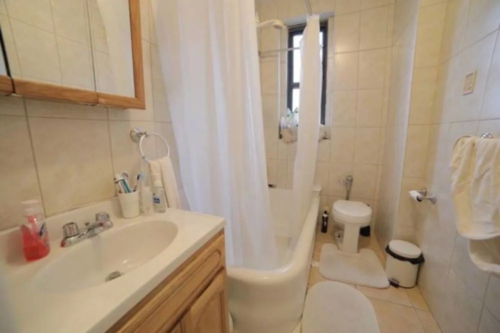 Compact, clean bathroom with bathtub.
