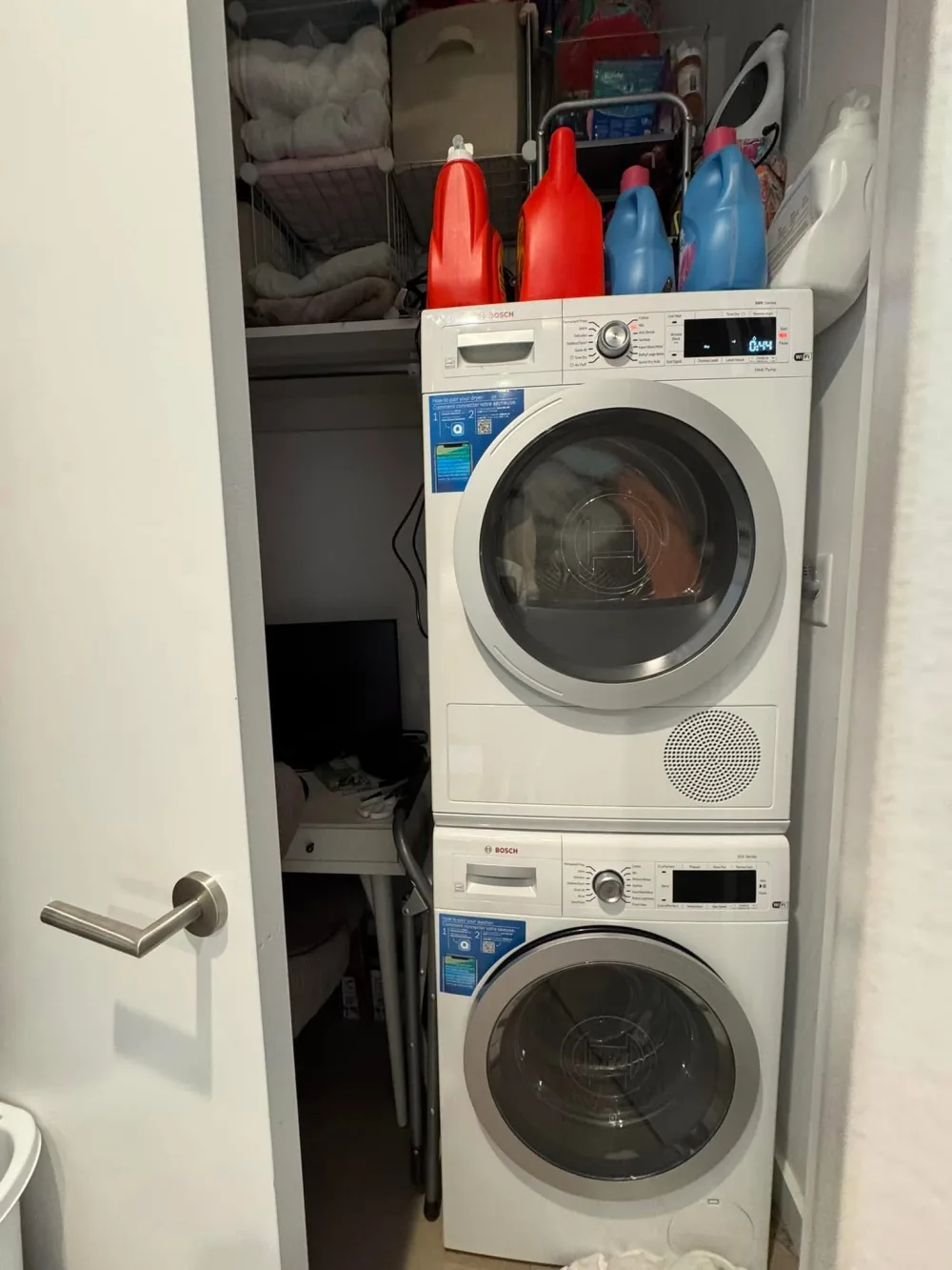 Laundry closet with stacked machines.