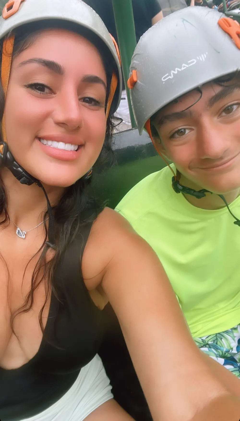 Smiling people wearing helmets outdoors.