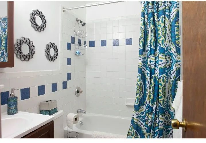 Bright bathroom with patterned curtains.