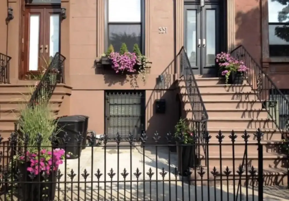 Brick townhouse with wrought iron fence.