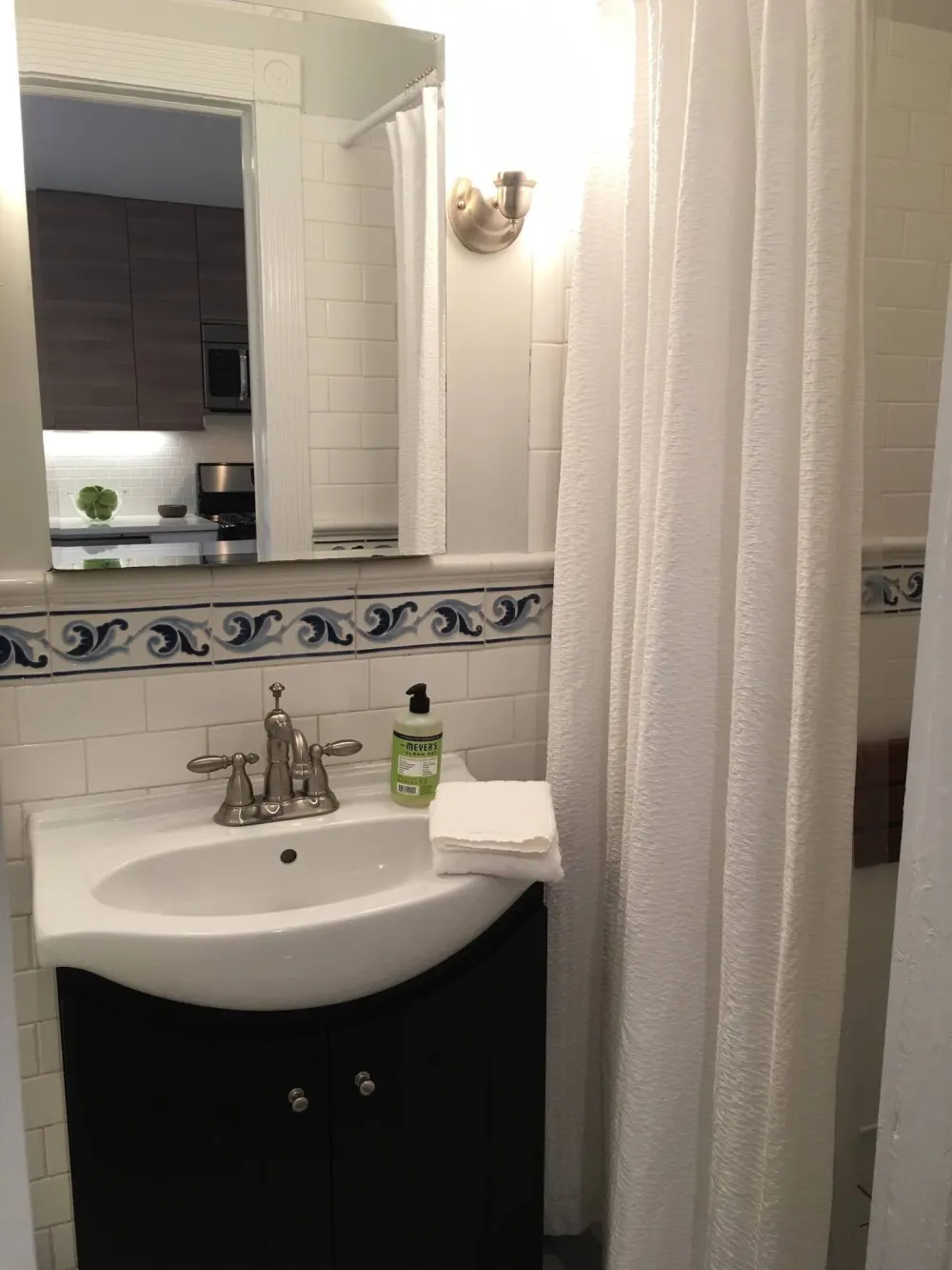 Compact bathroom with sink and shower.