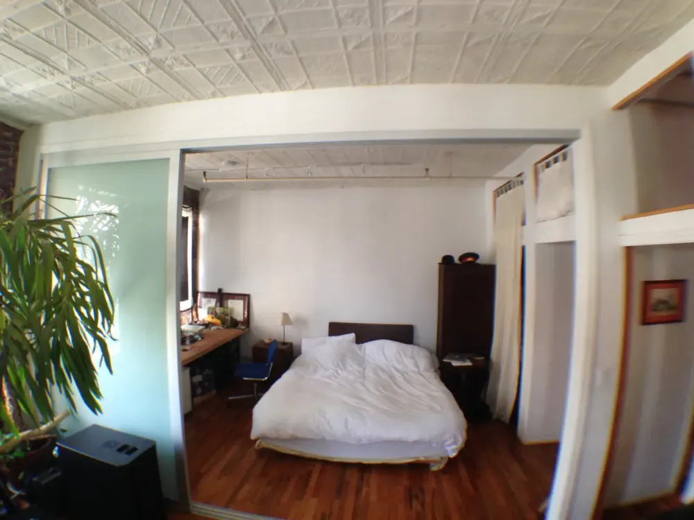 Cozy bedroom with wooden floor.