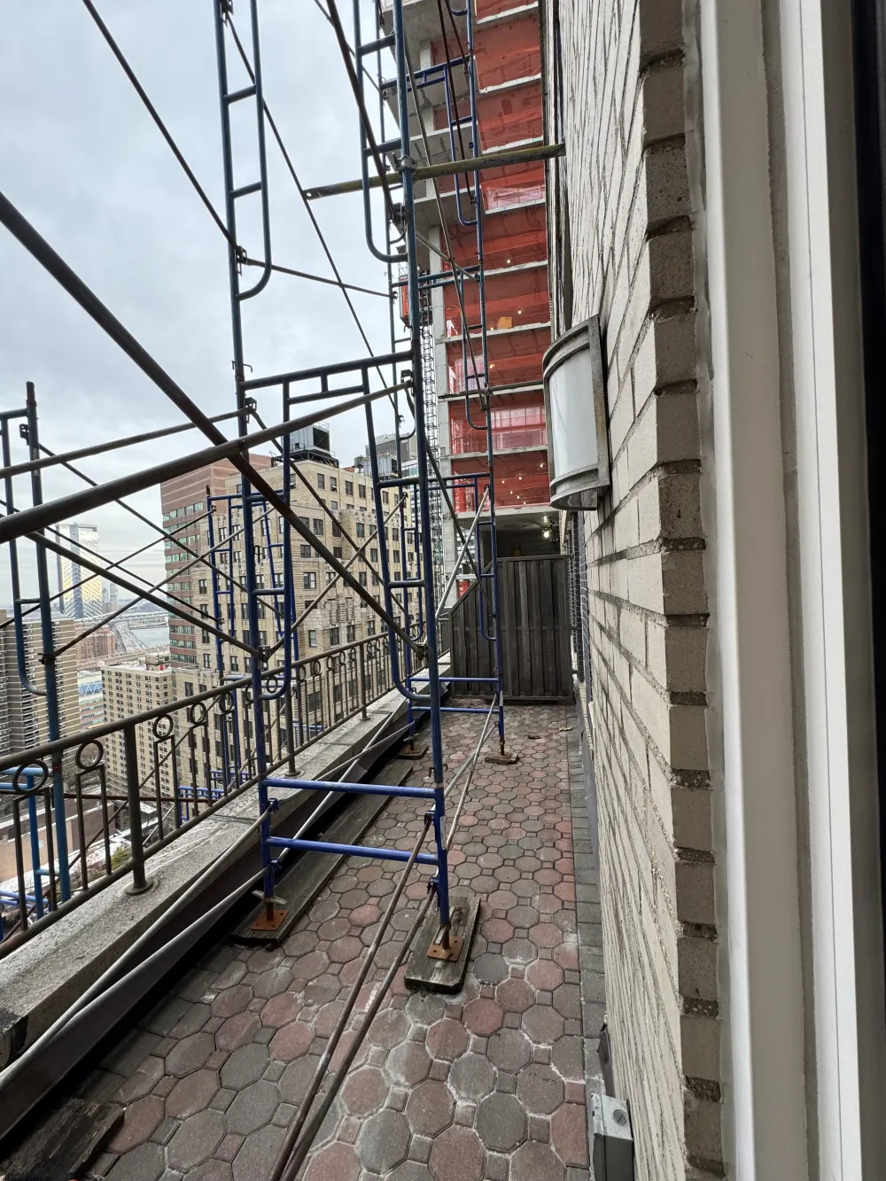 Balcony with construction scaffolding, cityscape.