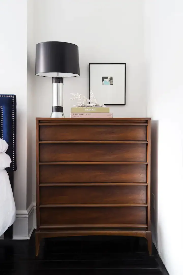 Wooden dresser with stylish lamp.