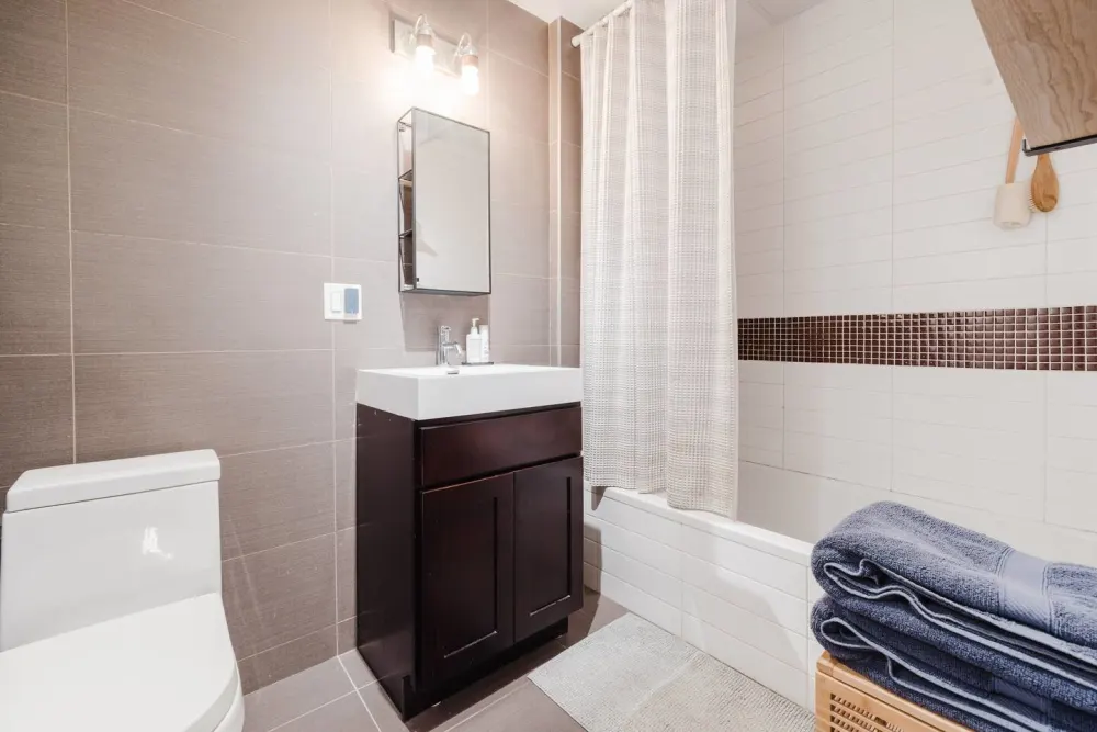 Modern bathroom with towels stacked.