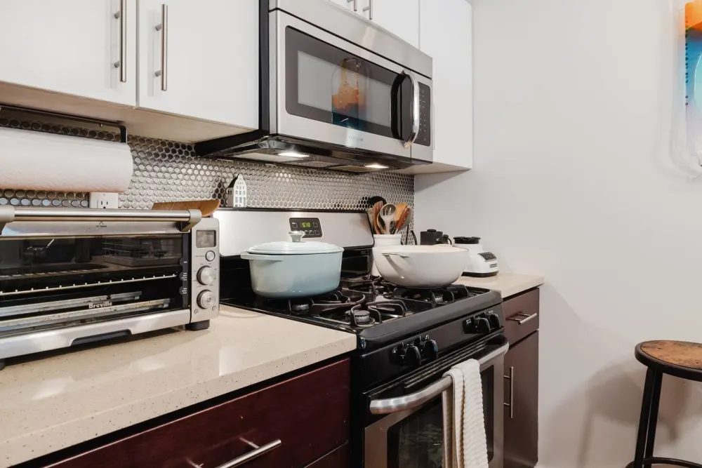 Modern kitchen with appliances and cookware.