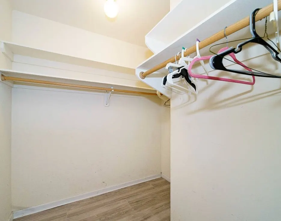 Spacious walk-in closet with hangers.