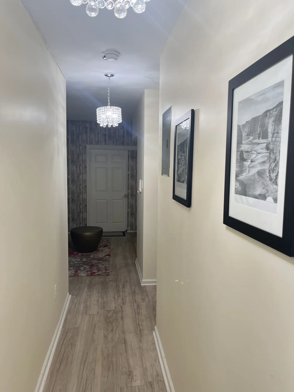 Bright hallway, wood floors, framed art.