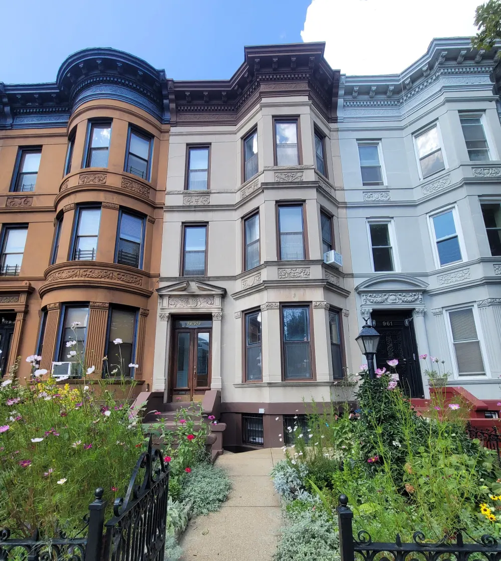 Three ornate townhouse facades, garden.