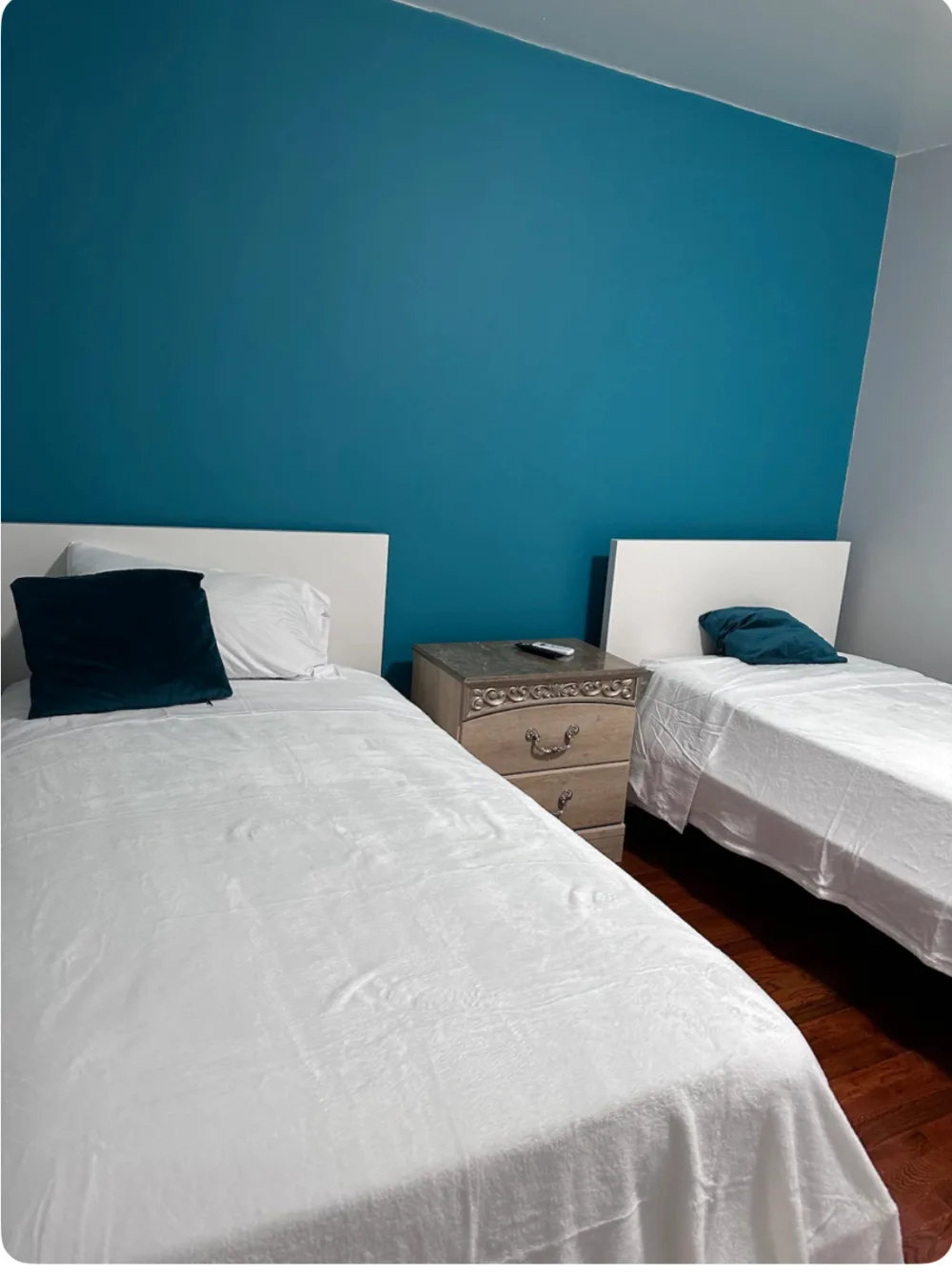 Two single beds, blue wall.