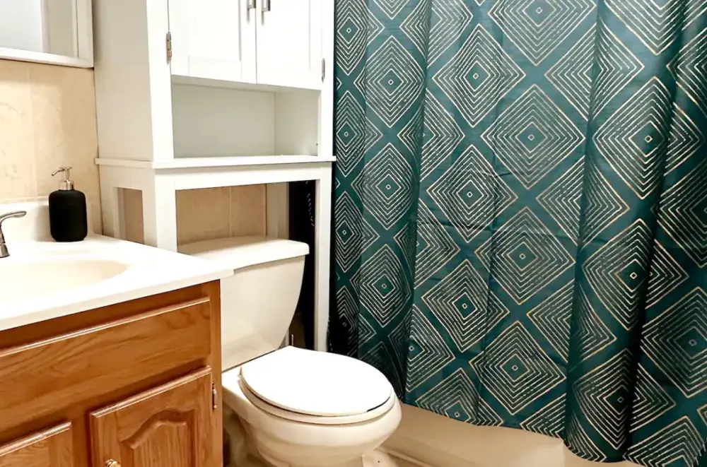 Clean bathroom with patterned curtain.