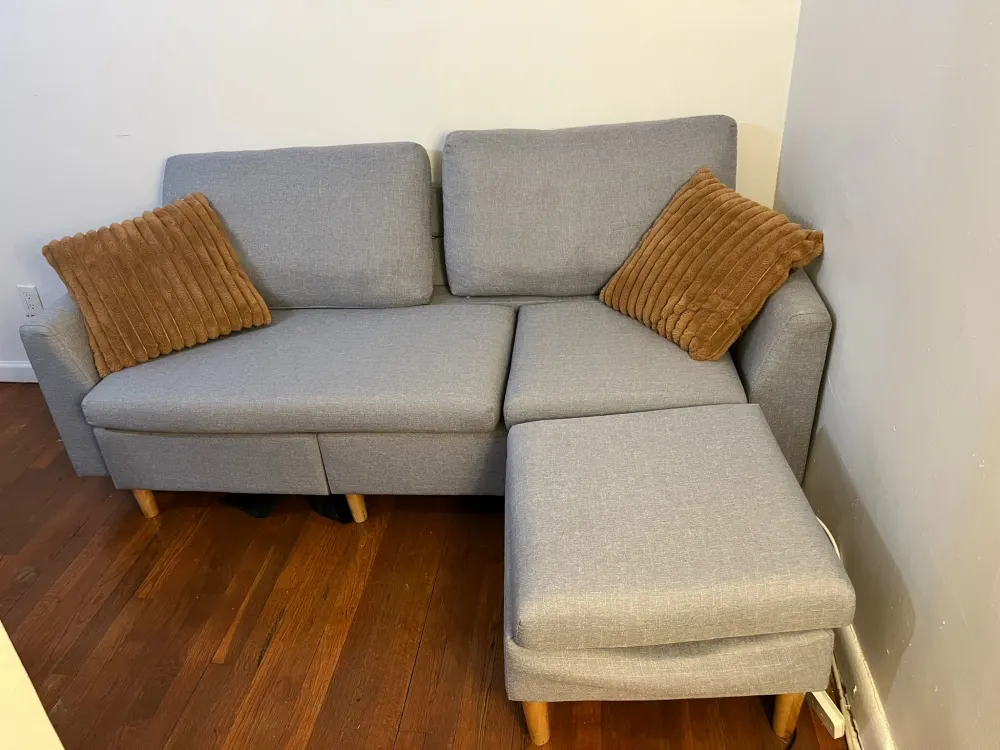 Gray sectional sofa with cushions.