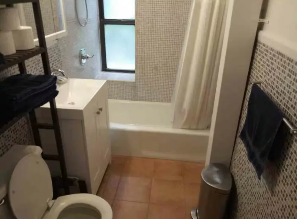 Compact bathroom with tub and window.