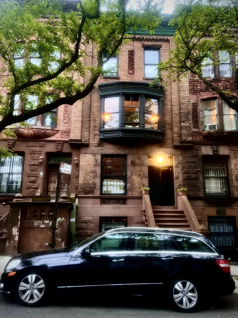 Historic brownstone with greenery outside.