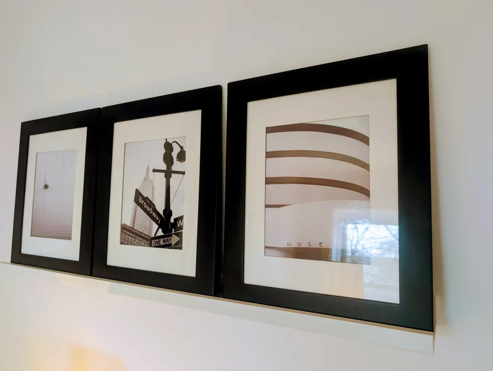 Three framed black-and-white photographs.