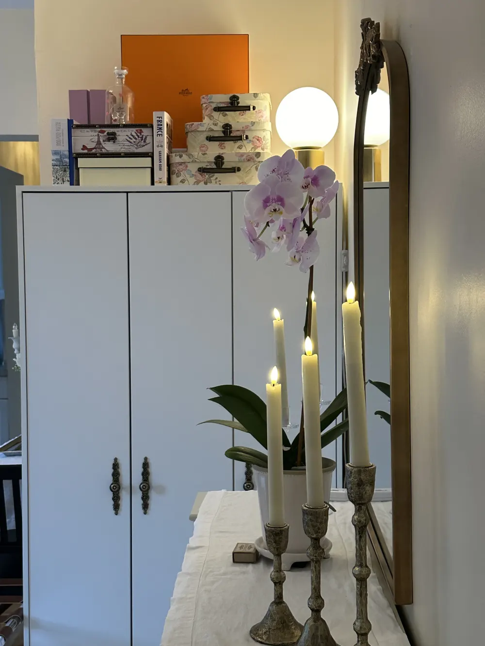 White cabinet with decorative candles.