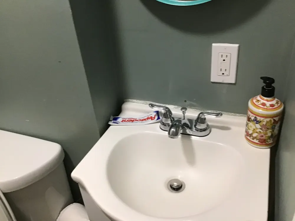 Small bathroom sink with toiletries.