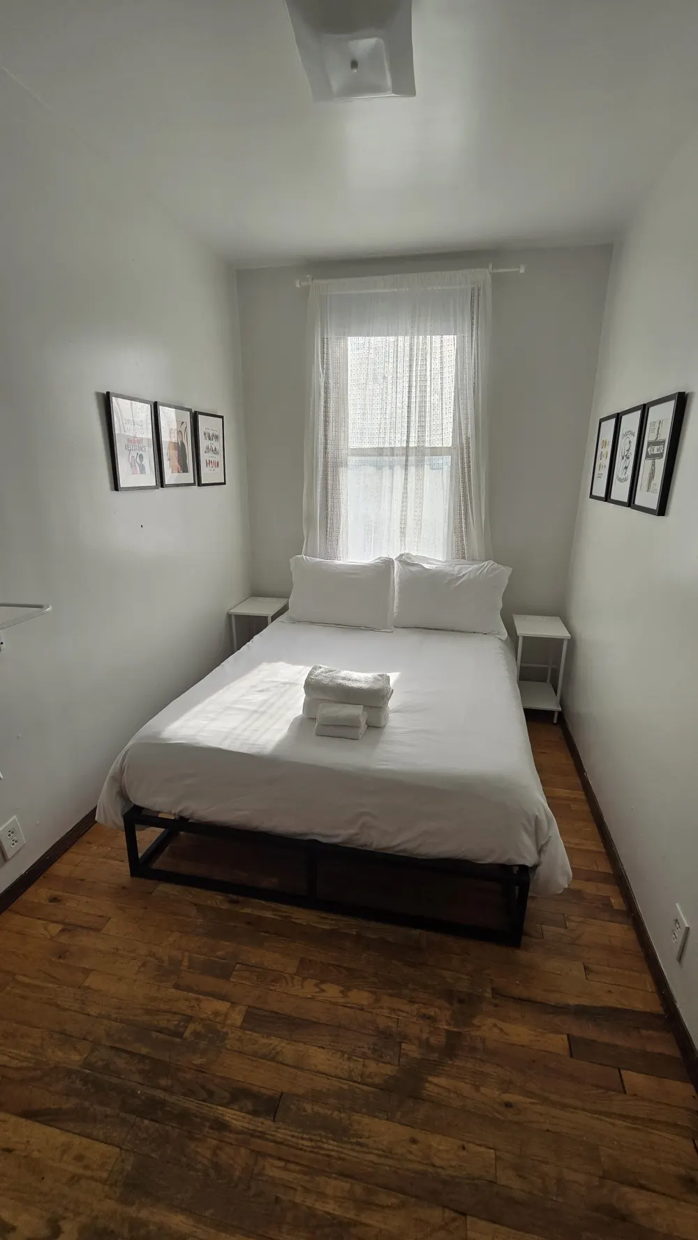 Small, cozy bedroom with artwork.