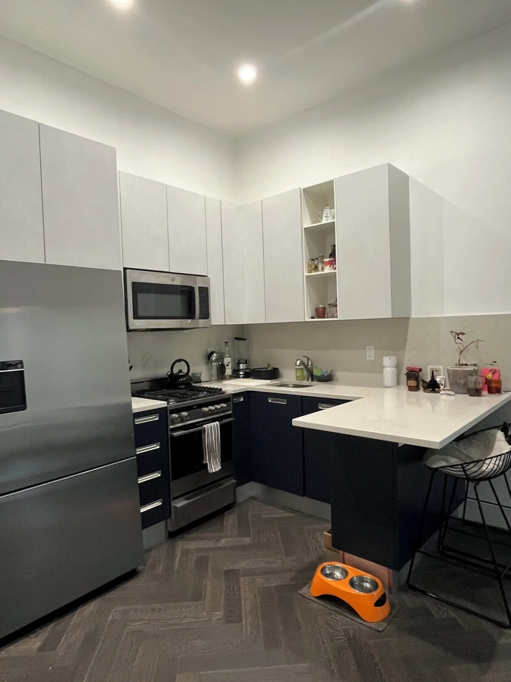 Modern kitchen with orange pet bowls.