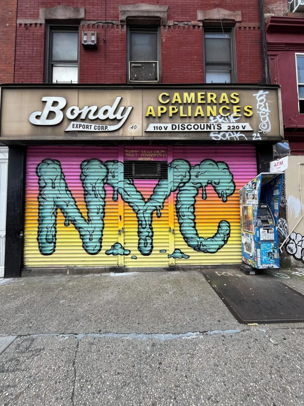 Graffiti "NYC" on storefront shutter.