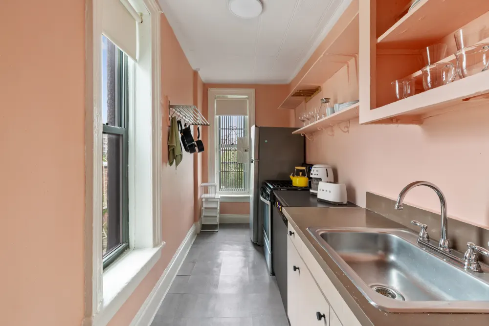 Narrow peach kitchen with appliances.