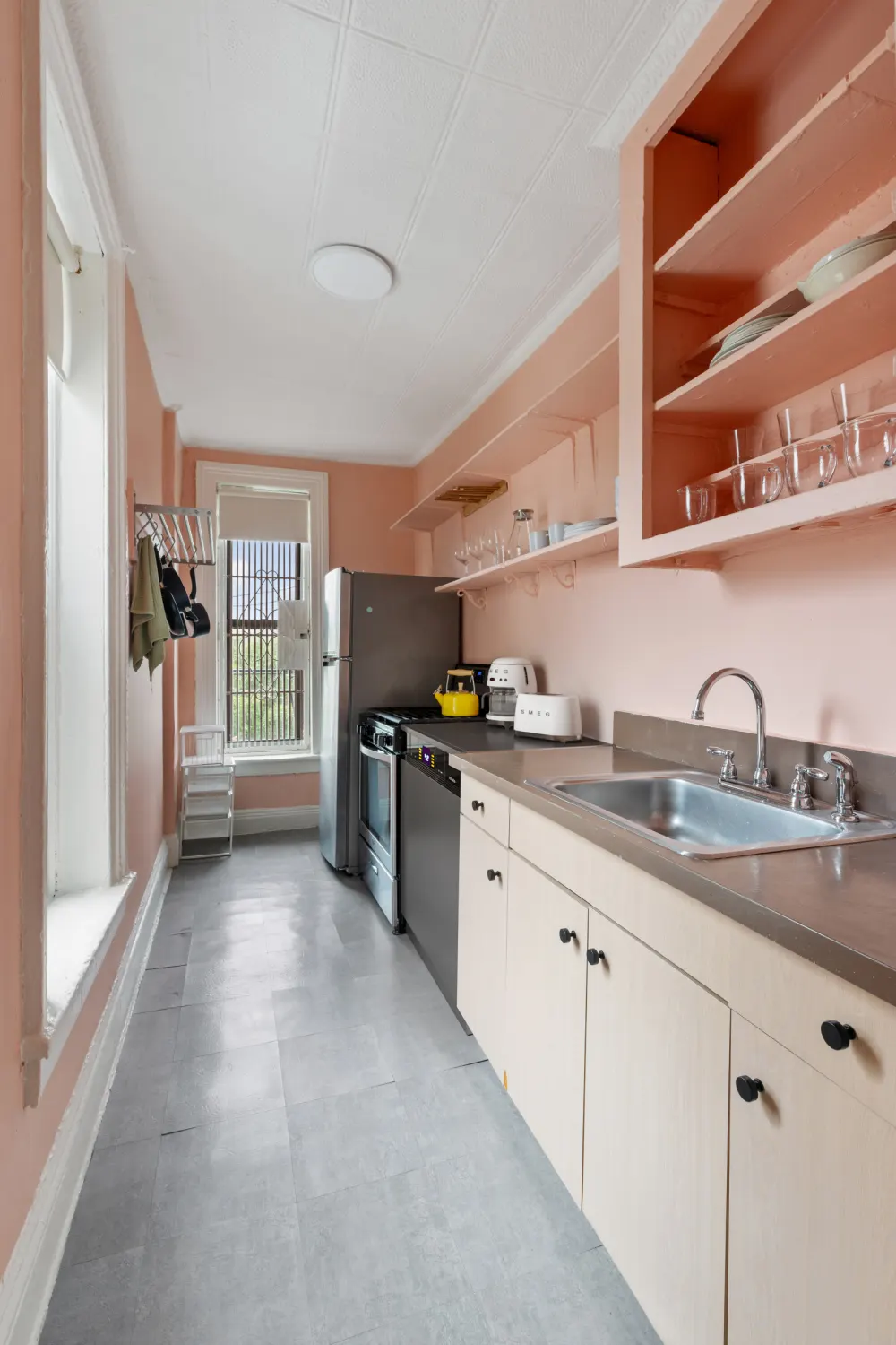 Narrow kitchen with peach walls.