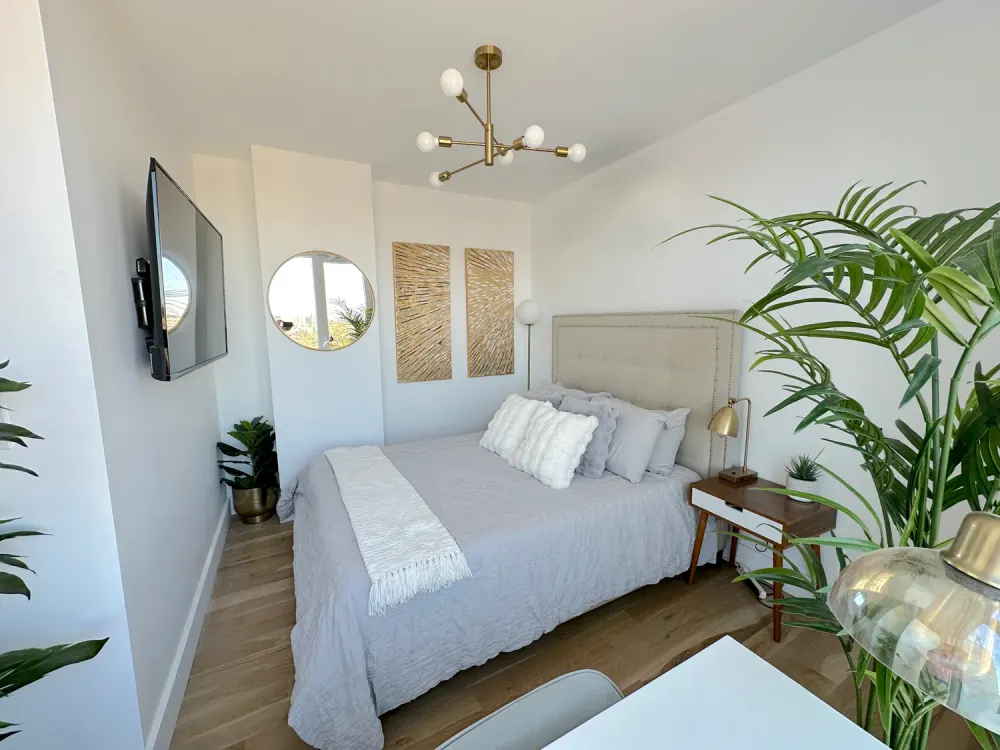 Modern, bright bedroom with plants.