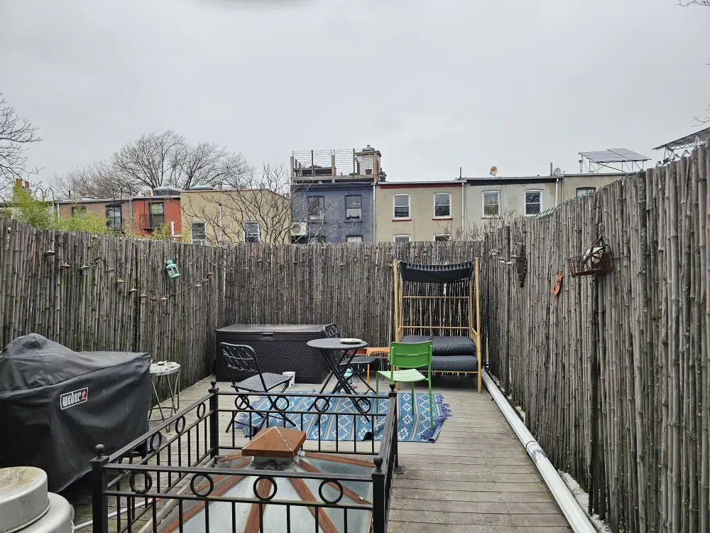 Cozy fenced patio with seating.