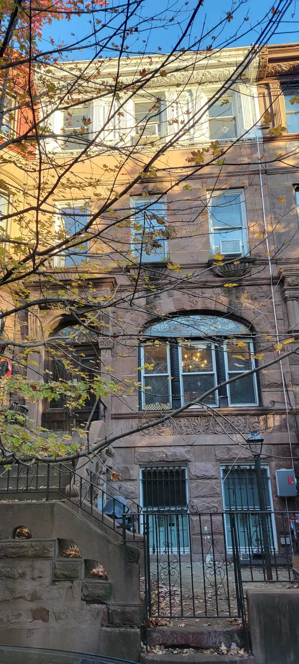 Historic brownstone building, autumn leaves.
