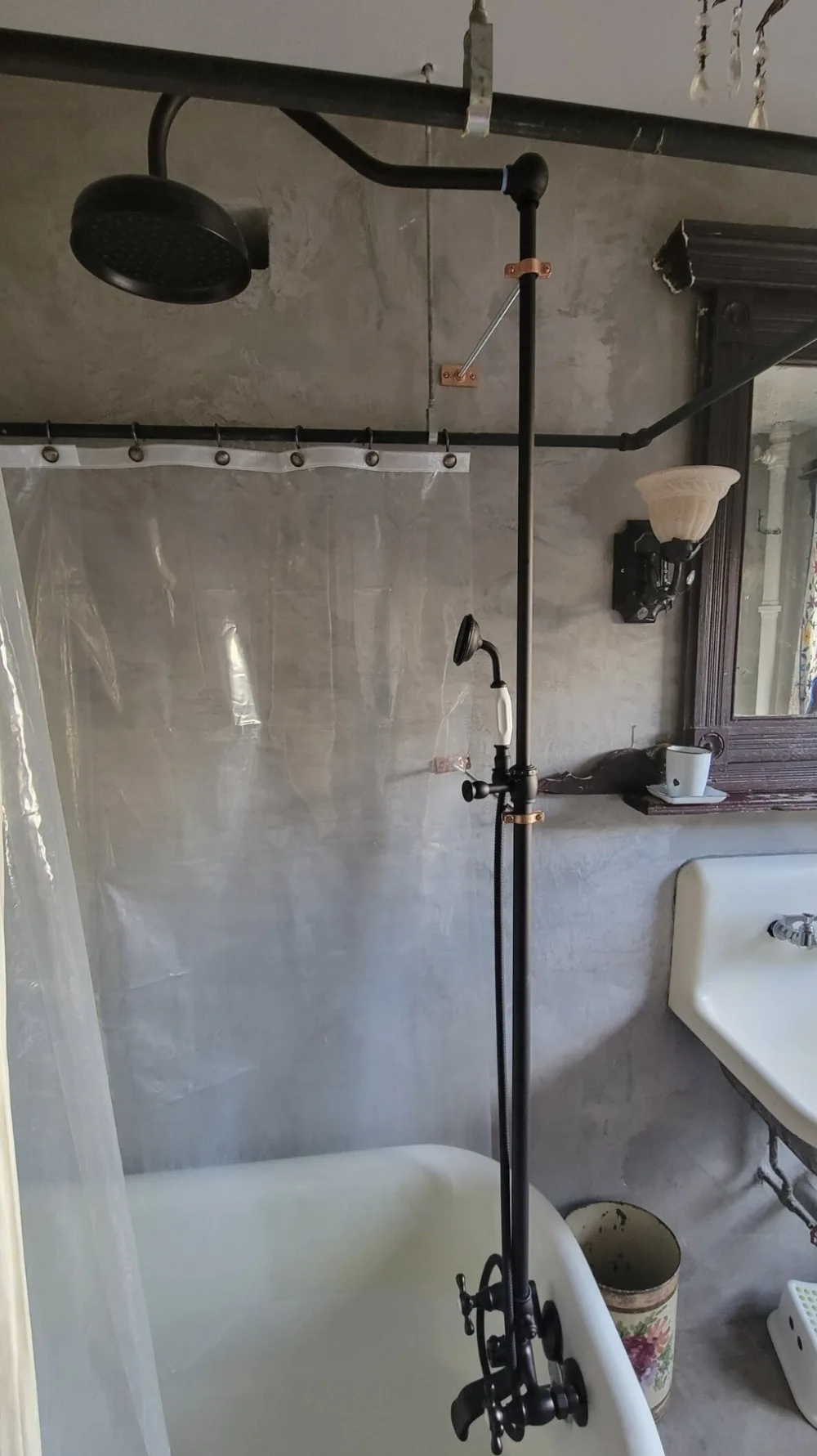 Industrial-style shower over clawfoot bathtub.