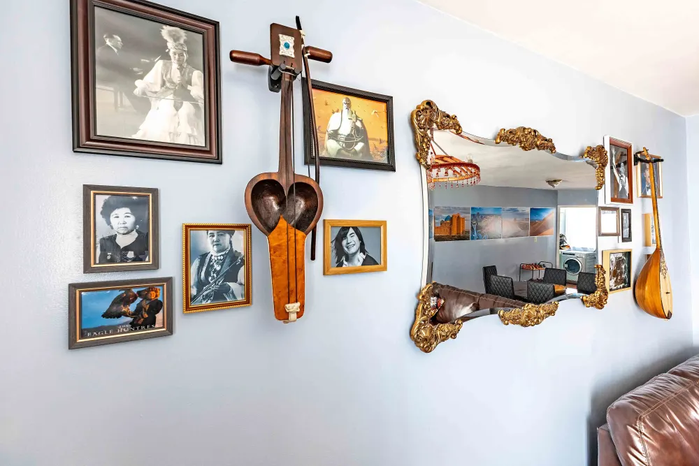 Framed portraits and traditional instruments displayed.
