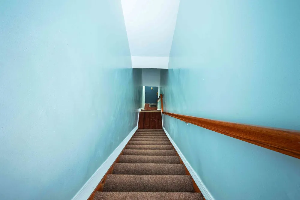Narrow staircase with blue walls.