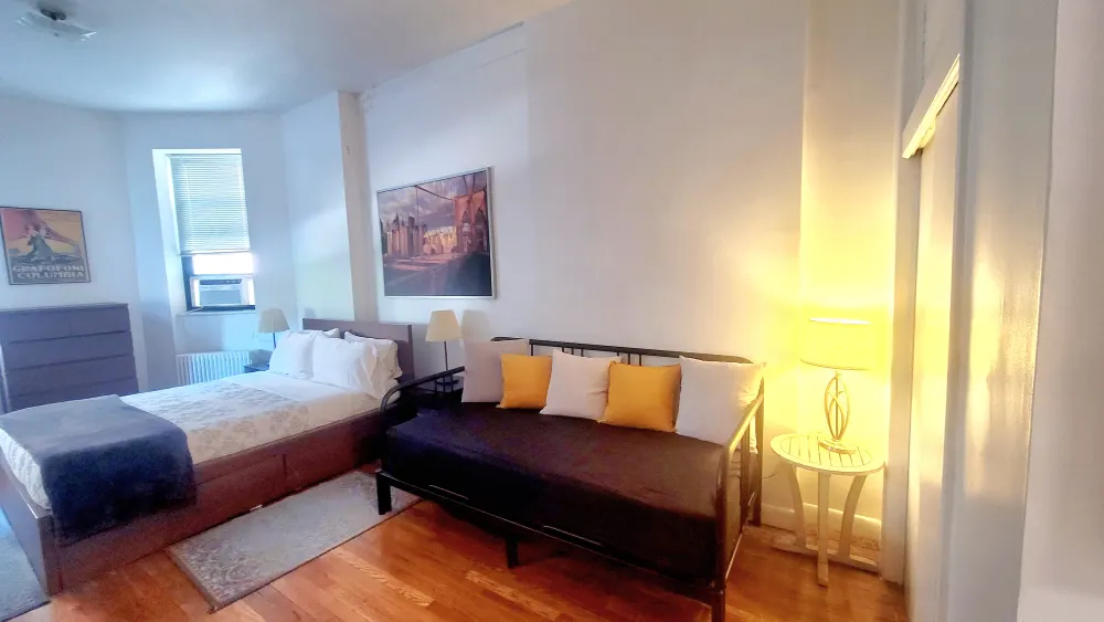 Bright bedroom with bed, sofa.