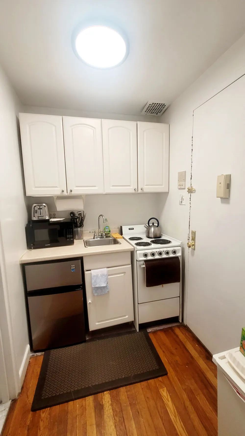 Compact kitchen with white cabinets.