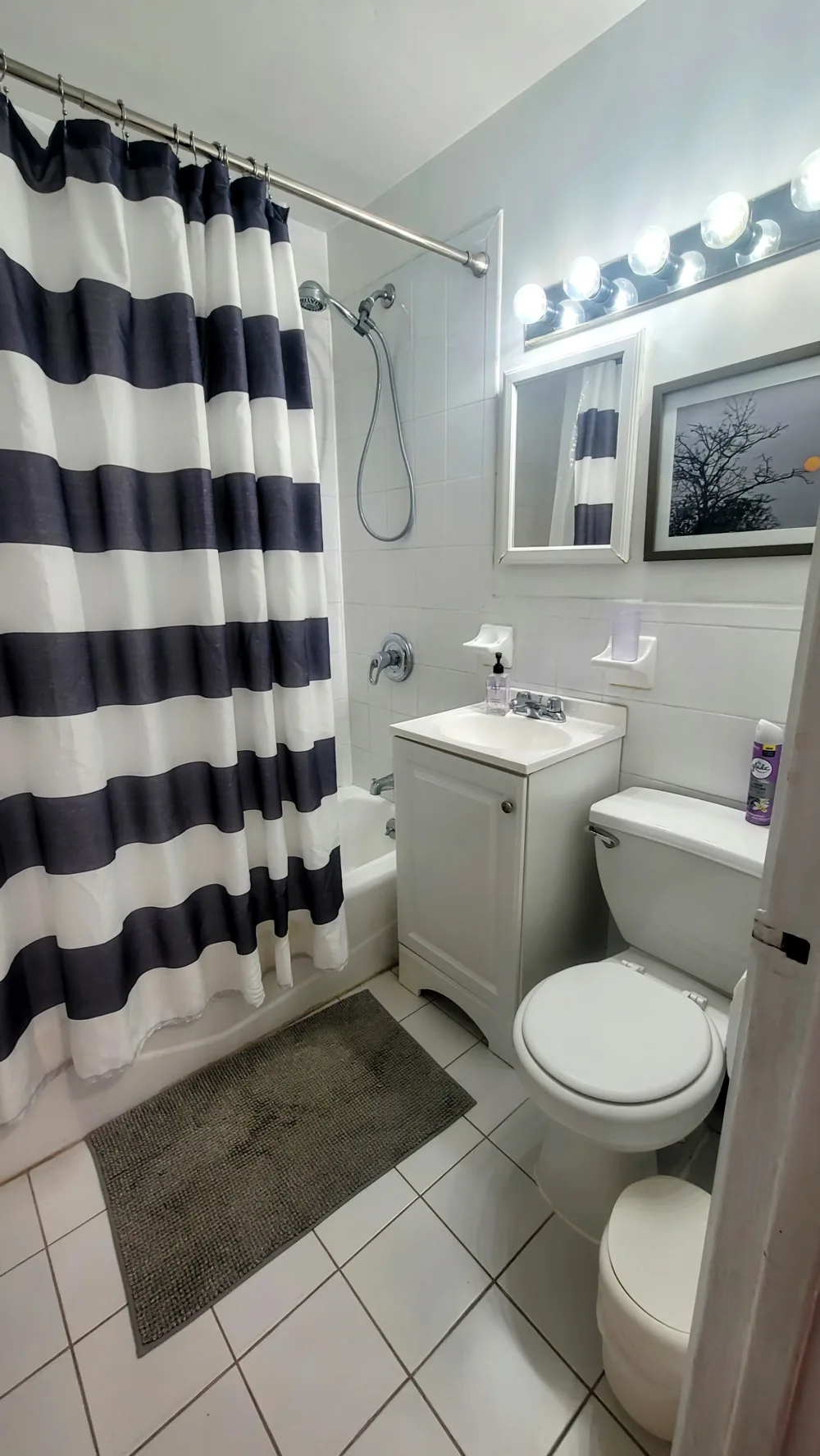 Modern bathroom with striped shower curtain.