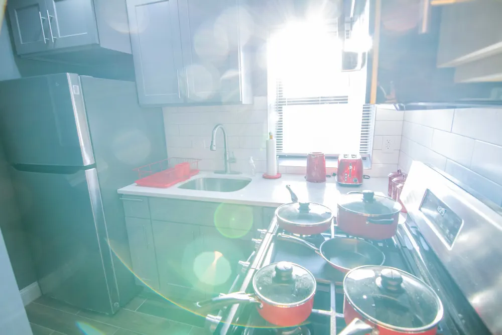 Sunlit modern kitchen with cookware.
