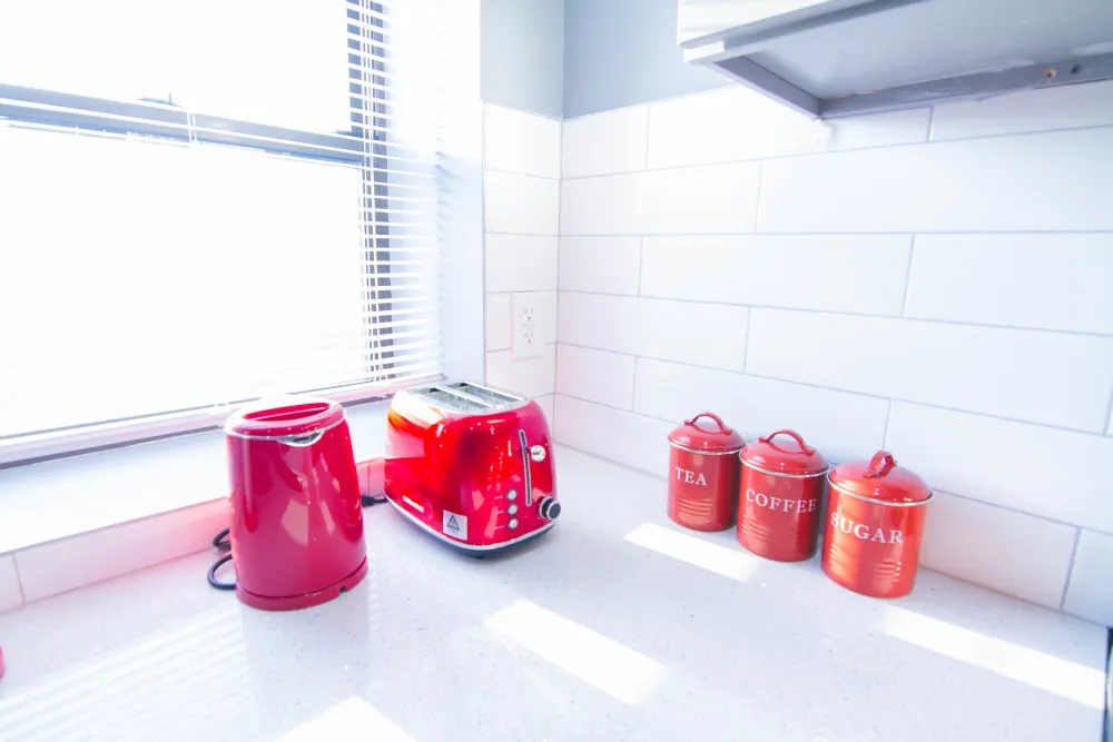 Bright kitchen with red appliances.