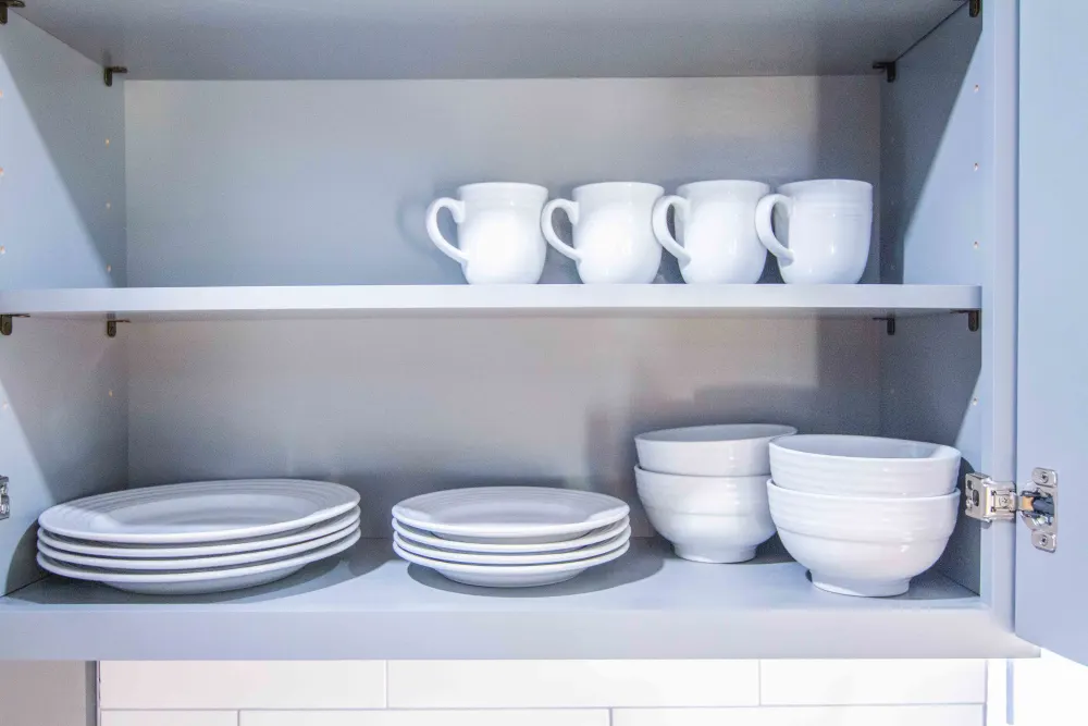 Neatly stacked white dishes cabinet.