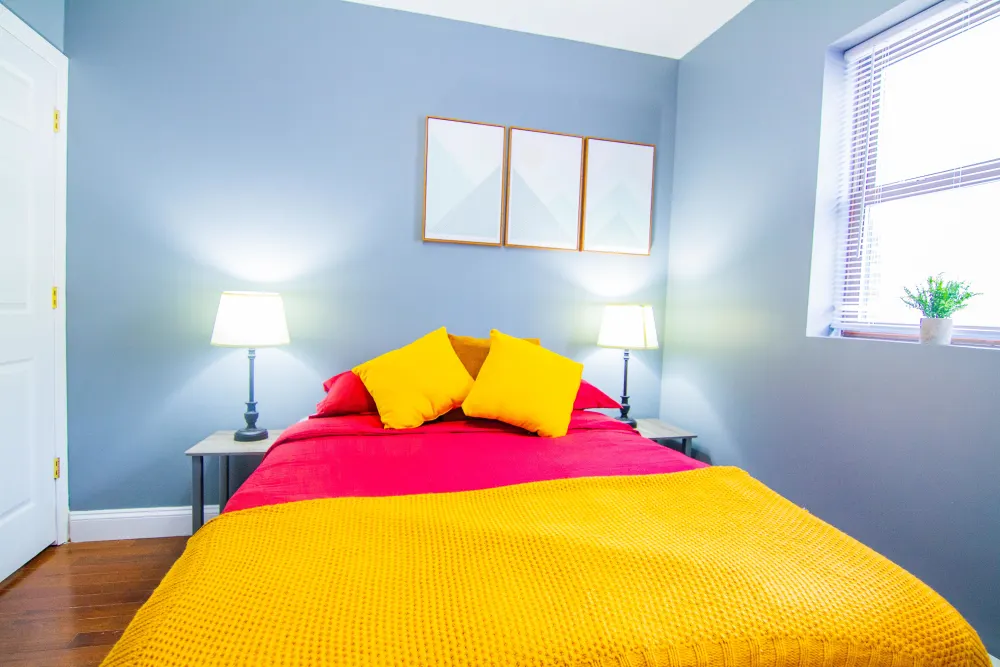 Bright cozy bedroom with colorful bedding.