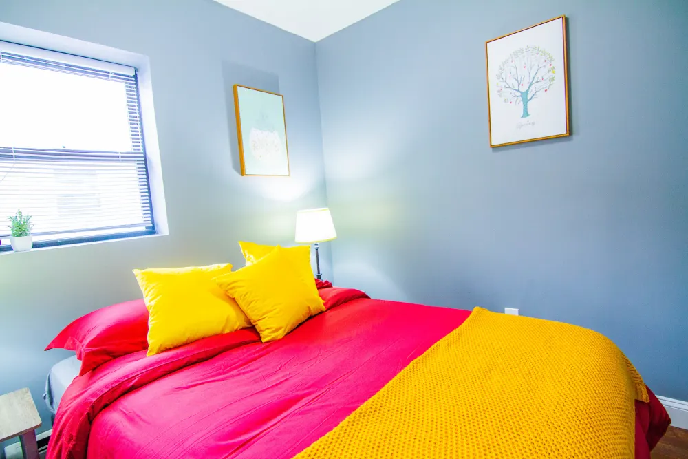 Bright, cozy bedroom with colorful bedding.