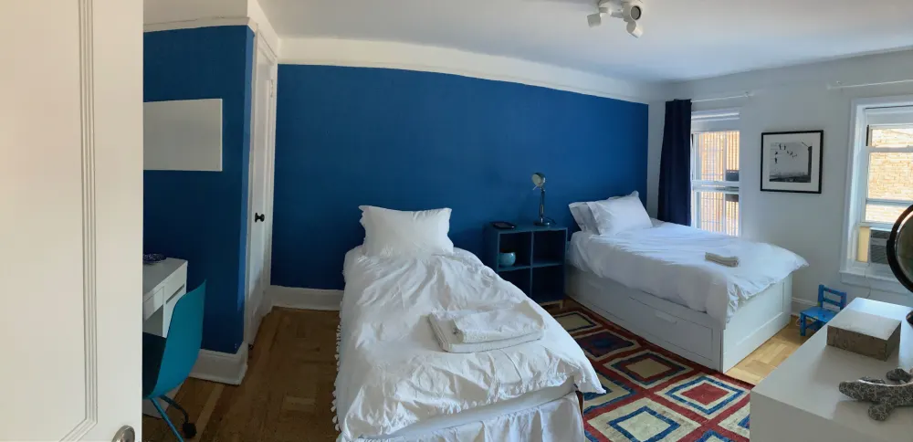 Two-bed room with blue walls.
