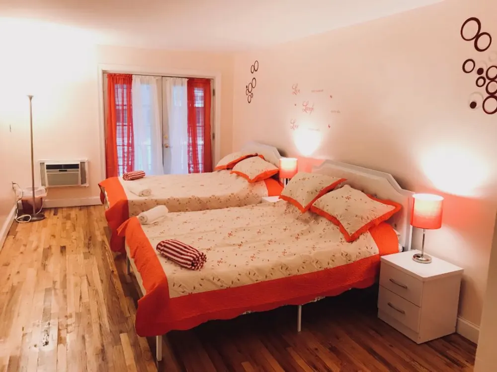 Bright twin room with orange accents.