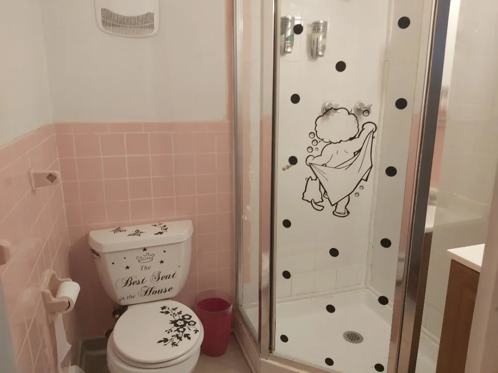 Quaint bathroom with pink tiles.