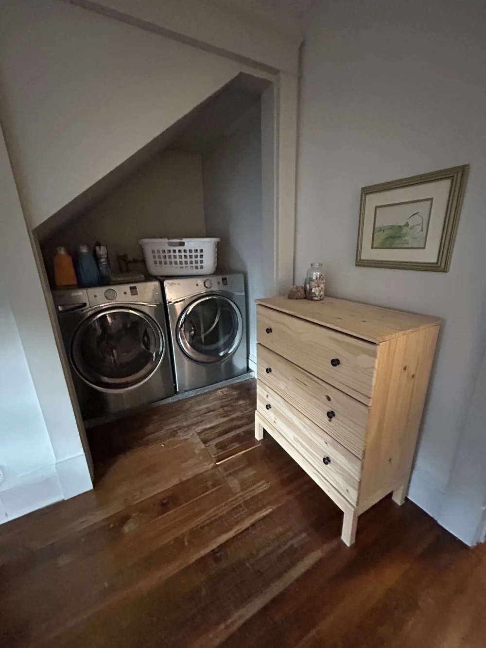 Laundry area with wooden dresser.